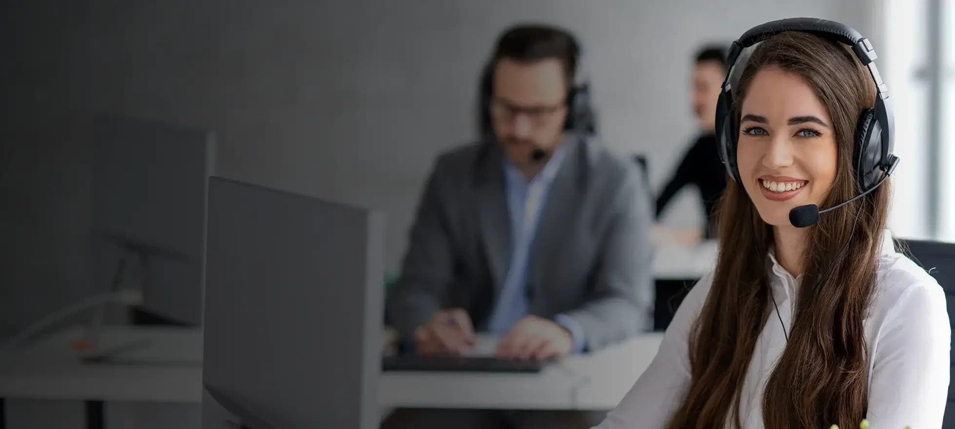 customer service agent with headset smiling in a call center